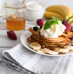 Pancakes with fresh berries and cream. Breakfast. On a wooden background