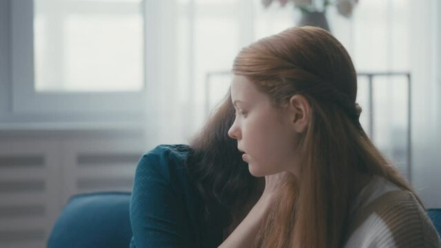 Middle-aged woman sharing secrets with teen daughter, close relationship, trust
