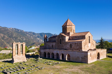 View of Odzun Church and funerary monument on sunny summer day. Lori Province, Armenia.