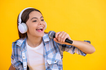 happy teenage singer girl singing music on background. singer girl with microphone in music studio....