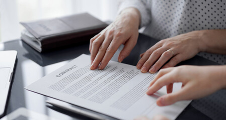 Business people discussing contract signing deal while sitting at the glass table in office, closeup. Partners or lawyers working together at meeting. Teamwork, partnership, success concept.