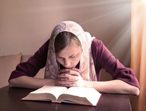 Girl reading a book by the window