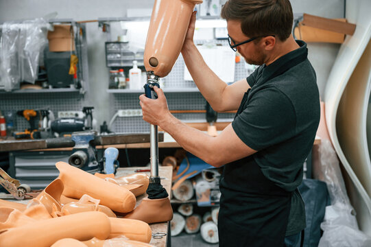 Checking the movement ability of product. Technician working with prosthesis in modern laboratory