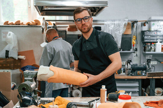 Almost finished product in hands. Technician working with prosthesis in modern laboratory