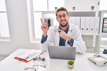 Hispanic man with beard wearing doctor uniform and stethoscope smiling and looking at the camera...
