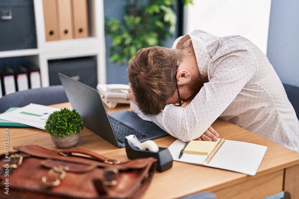 Wall mural Young redhead man business worker stressed using laptop at office