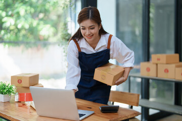 Starting small business entrepreneur of independent Asian woman smiling using computer laptop with...