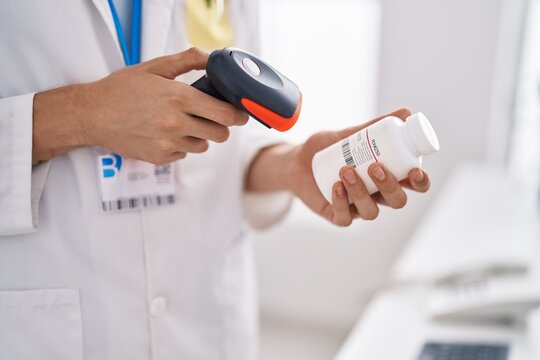 Young blond man pharmacist scanning pills bottle at pharmacy