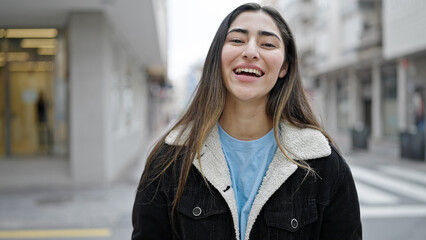 Young beautiful hispanic woman smiling confident standing at street