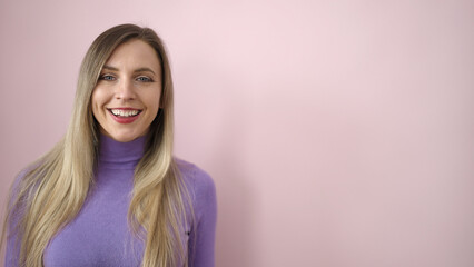 Fototapeta premium Young blonde woman smiling confident standing over isolated pink background