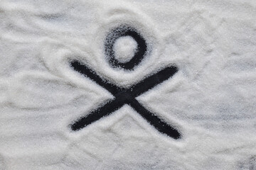 Background of scattered sugar with a figure of danger. The harm of sugar, the danger of excessive consumption