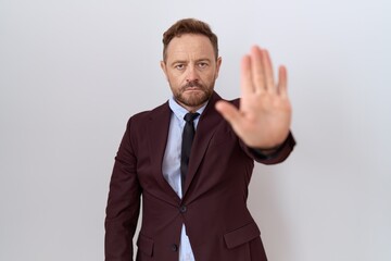 Middle age business man with beard wearing suit and tie doing stop sing with palm of the hand. warning expression with negative and serious gesture on the face.