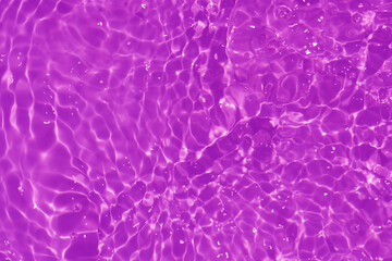 Purple water with ripples on the surface. Defocus blurred transparent pink colored clear calm water...