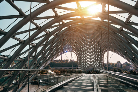 A close-up of a beautiful glass-and-steel footbridge with a glass roof. Against the background of the historical part of the city.