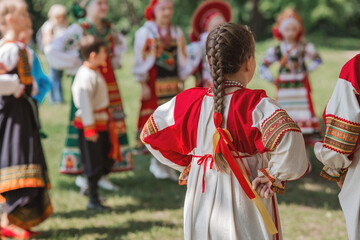 Russian folk traditions. Folk festivals. Children in beautiful Russian traditional outfits sing...