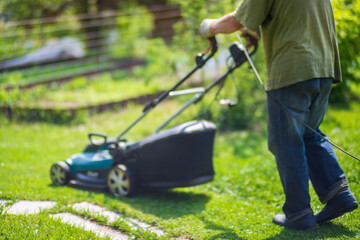 Lawn mover on green grass in modern garden or backyard. Machine for cutting lawns. Gardening care...