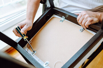 Middle aged man handyman fixing chair at home