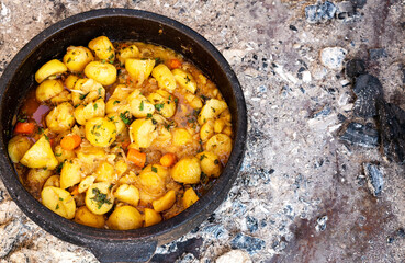 Potatoes in a cauldron cooked on charcoal, Serbian cuisine.