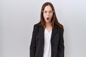 Obraz premium Beautiful brunette woman wearing business jacket and glasses in shock face, looking skeptical and sarcastic, surprised with open mouth