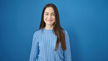 Young caucasian woman smiling confident standing over isolated blue background
