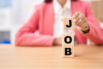 Business woman holding cubes with job word on the table