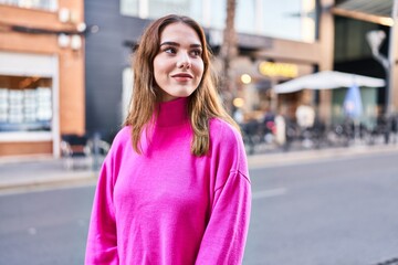 Fototapeta premium Young woman smiling confident looking to the side at street