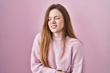 Fototapeta premium Young caucasian woman standing over pink background with hand on stomach because indigestion, painful illness feeling unwell. ache concept.