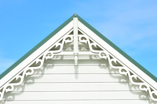 Gable end with weatherboard and ornamental fascia under green metal roof.