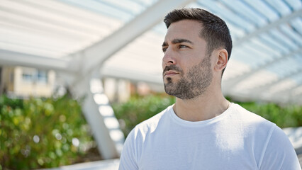 Fototapeta premium Young hispanic man looking to the side with serious expression at park