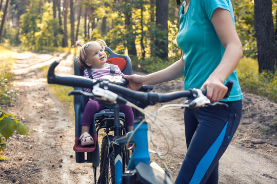 mom and baby ride a bike in a summer pine forest