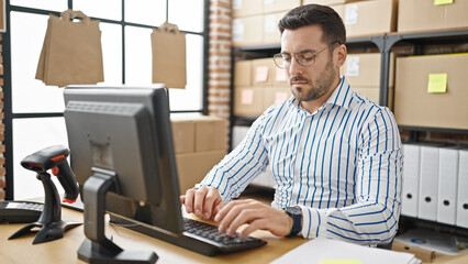 Young hispanic man ecommerce business worker using computer at office