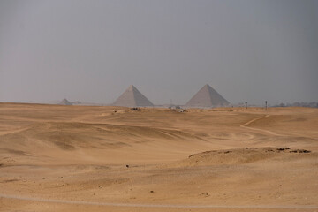 Fototapeta na wymiar Desierto de arena con pirámides de Guiza en el fondo
