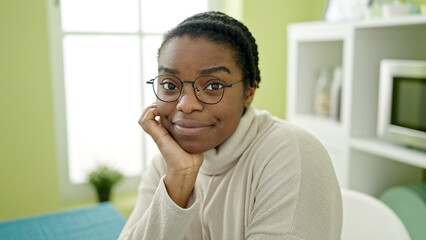 African american woman smiling confident sitting on table at dinning room