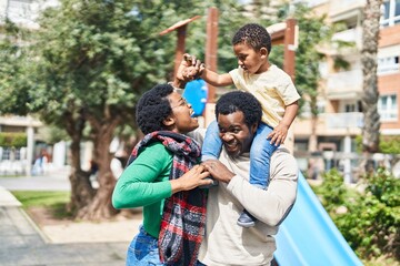 African american family holding boy on shoulders at playground