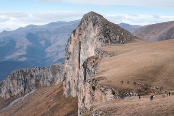 A group of tourists climbing up Mount Dimats on cloudy autumn day. Dilijan National Park, Tavush Province, Armenia.