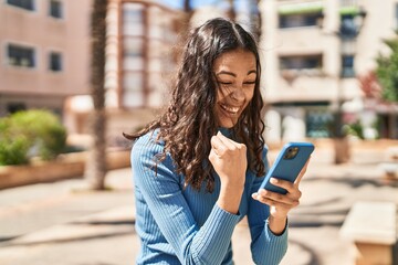 Young african american woman smiling confident using smartphone at park