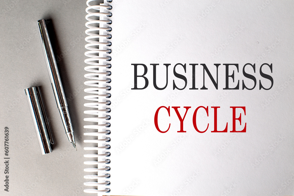 Poster business cycle text on a notebook with pen on grey background