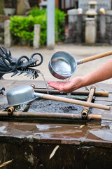 Person performing ablution, ceremonial purification rite known as temizu or chozu in Kyoto, Japan.