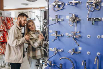 Married glad pleasant beautiful couple visiting furniture salon in search of shower mixer