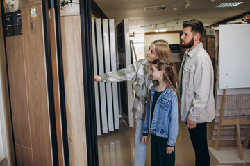 happy family chooses tiles for home in construction store