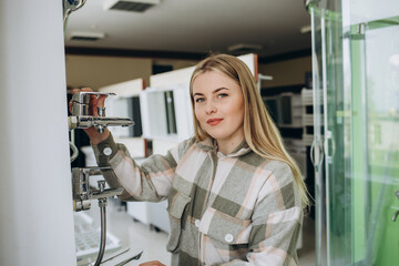 Fototapeta na wymiar a beautiful woman buys a kitchen faucet in a store