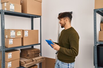 Young arab man ecommerce business worker using touchpad at office