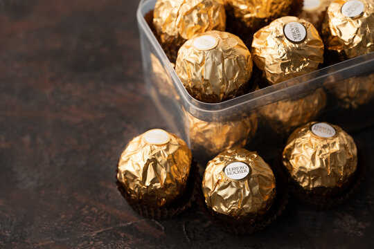 Dnipro. Ukraine 05.03.2023: Ferrero Rocher chocolate and hazelnut confectionery balls. Ferrero Rocher is a chocolate sweet made. Chocolate candies in a gold wrapper. Luxurious Design