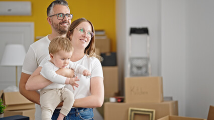 Family of mother, father and baby smiling together at new home