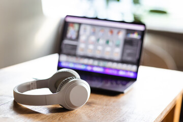 Modern wireless headphones and laptop computer while resting. Set up a workspace or home office to...