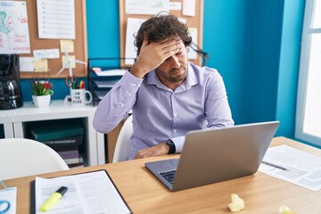 Young hispanic man business worker stressed using laptop at office