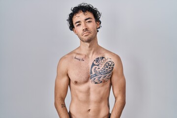 Fototapeta premium Hispanic man standing shirtless depressed and worry for distress, crying angry and afraid. sad expression.