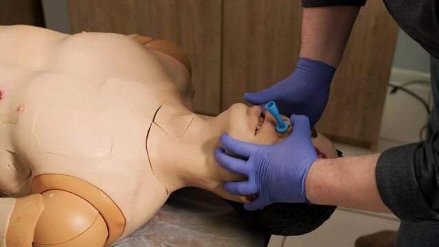 The tactical medic covers the wound with a bandage on the mannequin.
