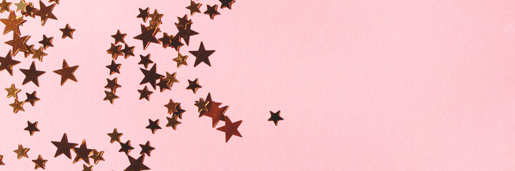 Banner with gold colored stars confetti on a pink background.
