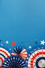 Concept of a July 4th celebration event. Top view flat lay of patriotic folding fans, blue, red, white stars on blue background with empty space for text or advert © Goncharuk film